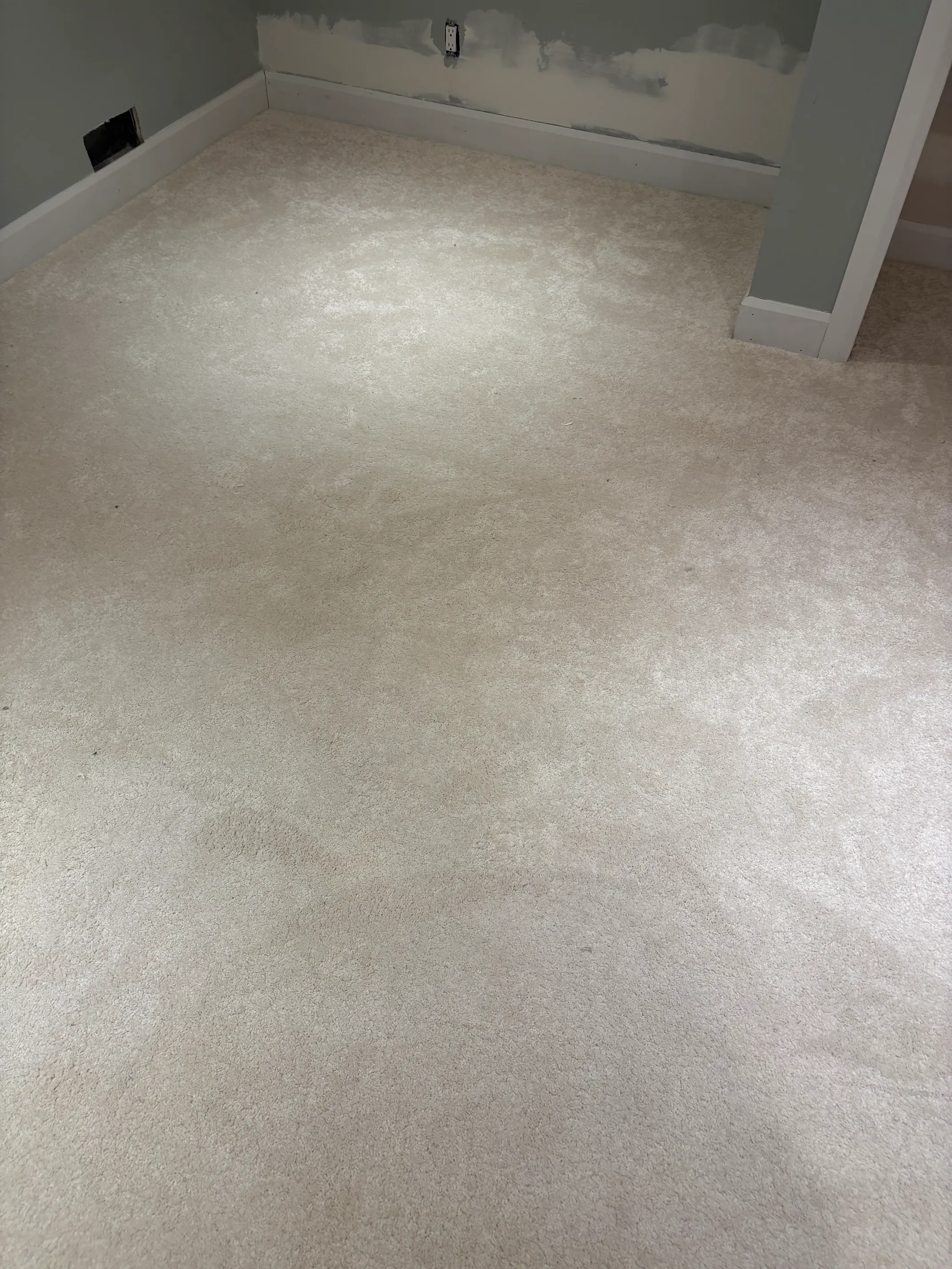 Installer laying carpet with moisture-barrier underpad in a finished Kanata basement